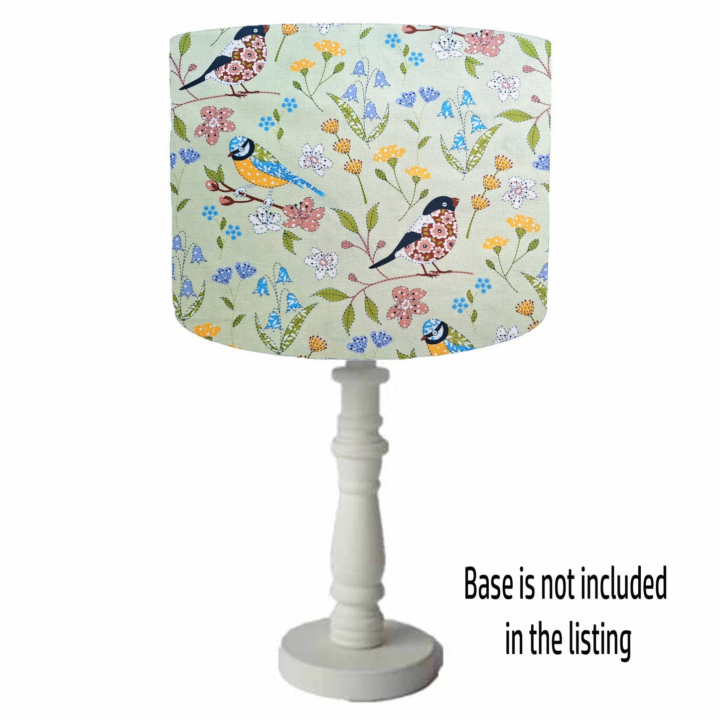 Birlds and flowers themed drum table lamp shade. With different birds set on a floral sage green background. Table lamp view