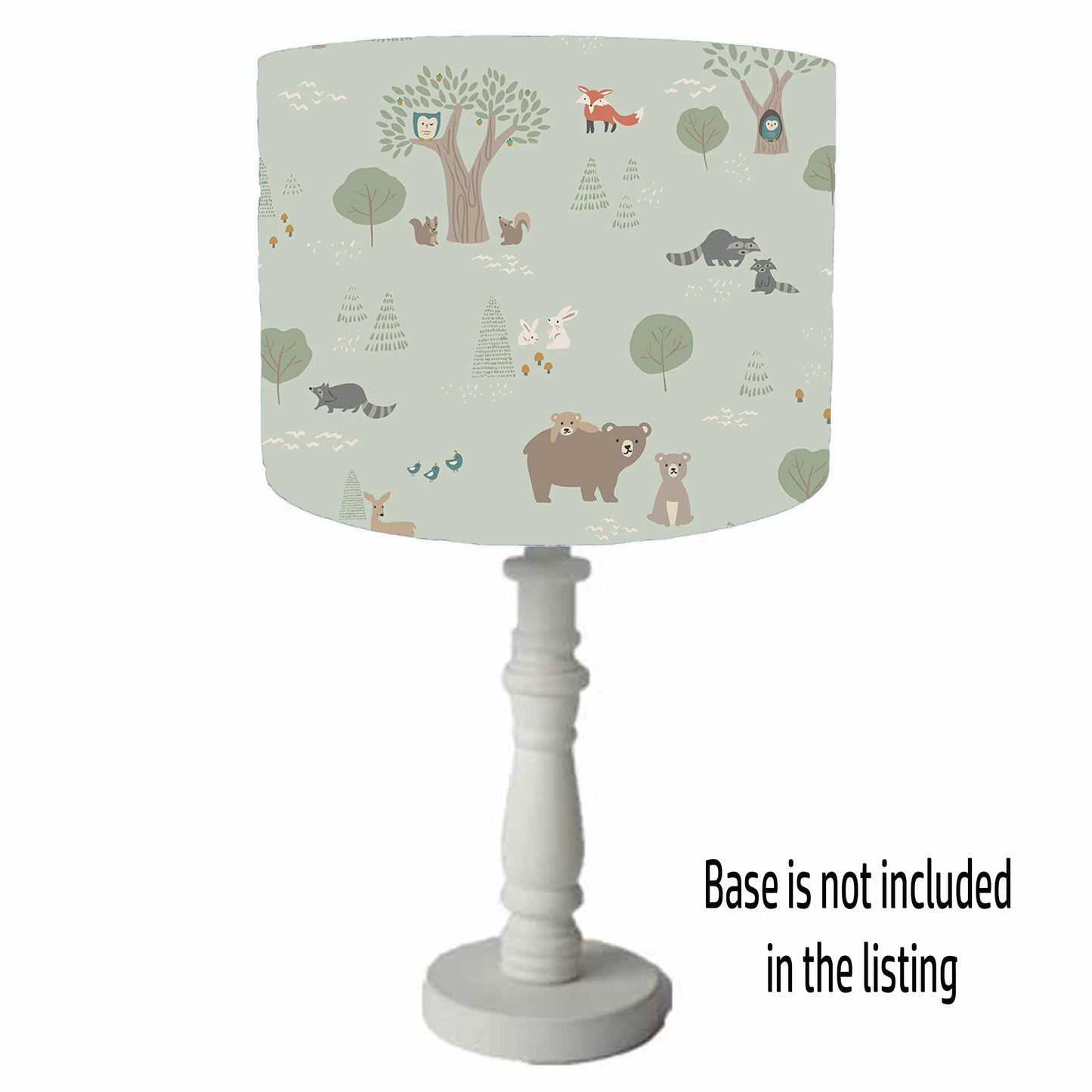Lamp with a forest-themed table lamp shade on a green background