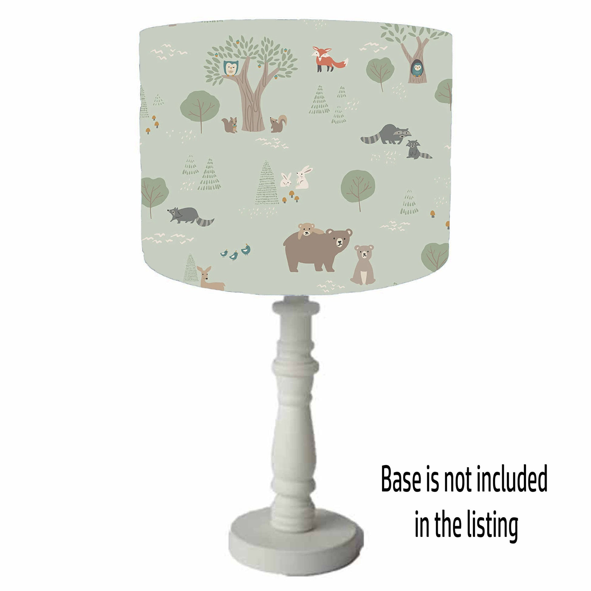 Lamp with a forest-themed table lamp shade on a green background