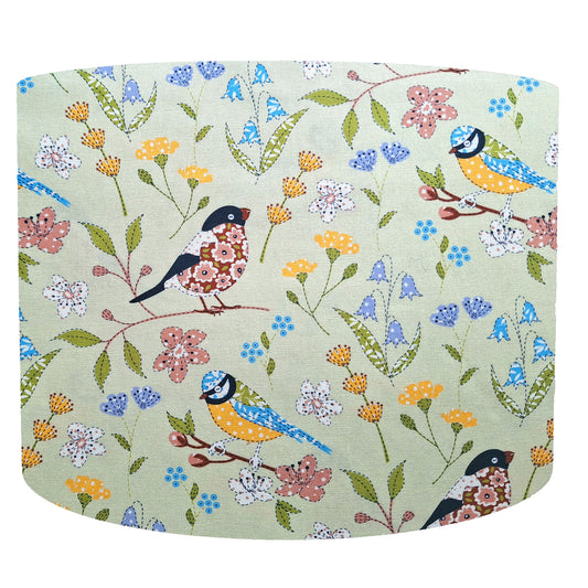 Colourful birds drum lampshade set on a floral green background. Front view
