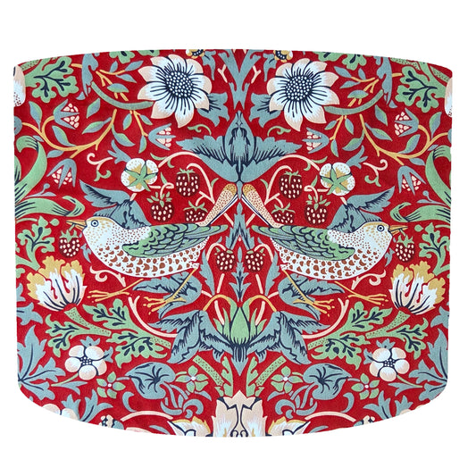 Beautiful William Morris Strawberry thief drum lampshade with a colorful floral and bird pattern on a red background