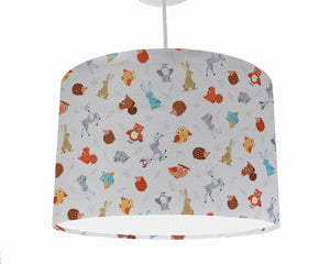 cream woodland lampshade with animals scattered on a cream background ceiling light shade